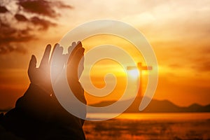 Christian woman praying worship at sunset. Hands folded in prayer. worship god with christian concept religion. Eucharist Therapy photo