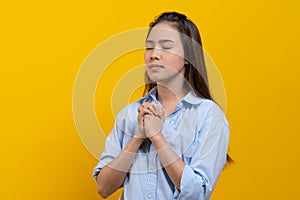 Christian women model praying isolated on yellow background shooting in studio