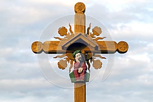 Christian wooden cross with Jesus Christ against bright sky outdoors