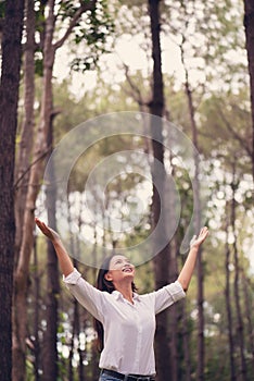 Christian worship with raised hand in pine forest,Happy woman de