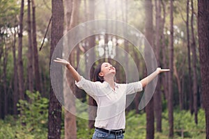 Christian worship with raised hand in pine forest,Happy woman de