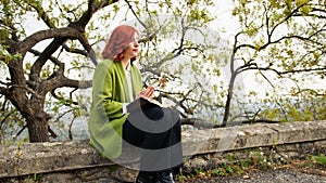 Christian Young woman prays at sunset seated under the tree