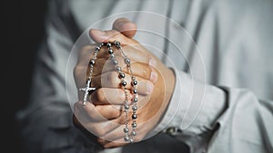 Christianity background of man hand holding rosary praying for god blessing