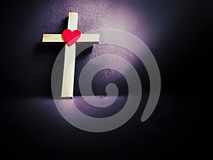 Christianity Concept - Cross shaped with red heart shaped background. Stock photo.