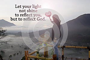 Christianity inspiraitonal quote - Let your light not shine to reflect you, but to reflect God. With woman standing holding sign. photo