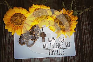 Christianity inspirational quote - With God all things are possible. With wooden Rosary, sunflowers, notebook white paper