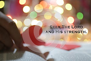 Christianity inspirational quote - Seek The Lord and His strength. Bible motivational words with blurry heart in hand.