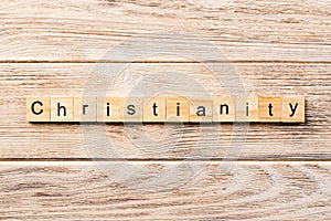 Christianity word written on wood block. christianity text on table, concept