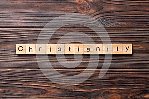 Christianity word written on wood block. christianity text on table, concept