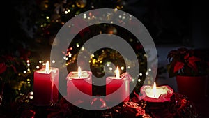 Christmas 4 candles flame red,flowers with illuminated tree to background