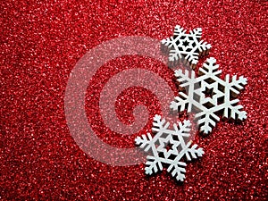 Christmas abstract background. Abstract bokeh lights. Shiny sparkle metallic glitter texture. White decorative snowflake on a red