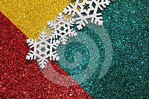 Christmas abstract background. Bokeh lights. Shiny sparkle metallic glitter texture. White decorative snowflake on red, green,