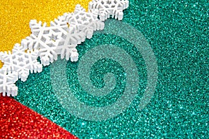 Christmas abstract background. Bokeh lights. Shiny sparkle metallic glitter texture. White decorative snowflake on red, green,