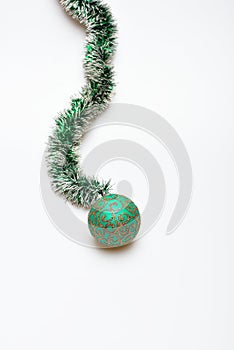 Christmas accessory concept. Tinsel with christmas ball toy, white background, copy space. Decoration for Christmas with
