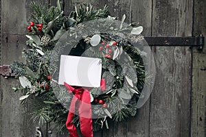 Christmas advent wreath. Floral garland of fir, pine tree branches. Red berries and silk ribbon. Blank greeting card