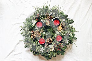 Christmas advent wreath isolated on white table background. Decorated by evergreen fir tree branches, eucalyptus leaves