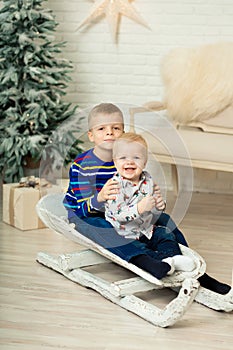 Christmas is already here. Two brothers sledding with christmas gift box. Small cute boy received holiday gifts. Kid hold gift box