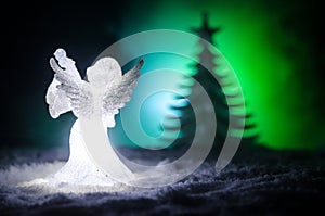 Christmas Angel glass xmas figure and glass fir tree, christmas tree, docorative elements on dark background. Christmas decoration