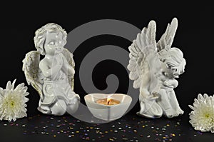 Christmas angels with flowers for gifts, isolated on black