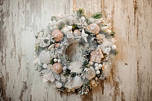 Christmas artificial wreath with white and rosa color toys, balls, tapes and flowers photo