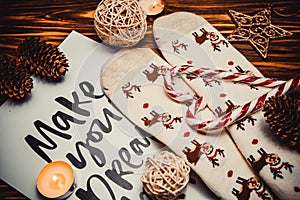 Christmas decorations and socks on wooden brown background with candle