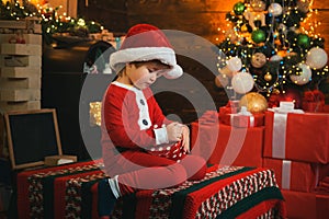 Christmas attributes. Present box. Childhood moments. Xmas tree. Christmas interior. Little boy decorating xmas tree and