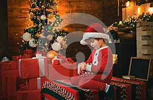 Christmas attributes. Present box. Childhood moments. Xmas tree. Christmas interior. Little boy decorating xmas tree and