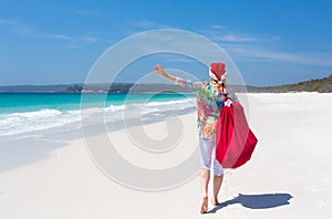 Christmas in Australia - festive woman walking along idyllic beach summer