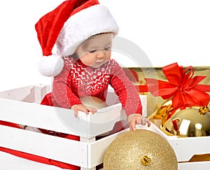 Christmas baby child in santa hat holding gold ball decoration n