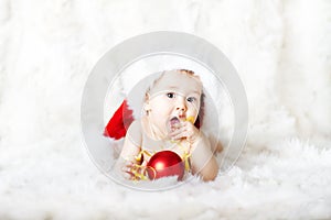 Christmas baby in red hat lying on fur