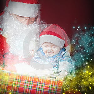 Christmas baby and Santa opening a present or gift box