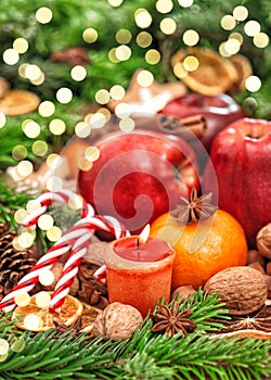 Christmas backdround Fruits spices andles golden lights