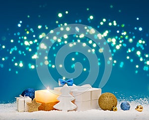 Christmas background with Advent candle and decoration on white snow.