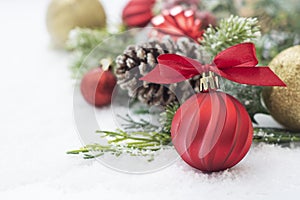 Christmas background with balls, baubles and green fir branches, pine cones, on white snow background. Winter holidays. Christmas