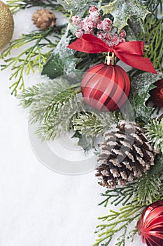 Christmas background with balls, baubles and green fir branches, pine cones, on white snow background. Winter holidays. Christmas