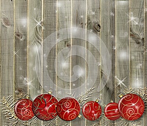 Christmas background - baubles and branch of spruce tree on grunge wooden board