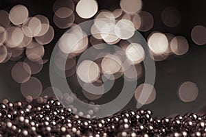 Christmas background, with blurred Christmas lights, beautiful bokeh and a chain of glossy balls in the foreground. Christmas