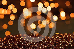 Christmas background, with blurred Christmas lights, beautiful bokeh and a chain of glossy balls in the foreground. Christmas