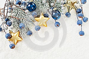 Christmas background border with corner composition made of green Xmas fir branch, blue berries and gold New Year decoration