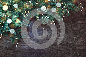 Christmas background with border of fluffy green fir branches on a textured dark brown wood