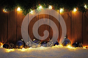 Christmas background with branches, lights and blue baubles