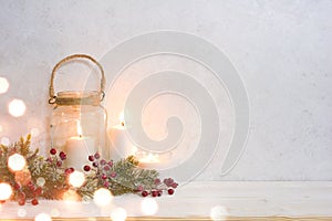 Christmas background, burning lantern candles decorated with frosted fir branches