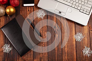 Christmas background for businessmen, leather notebook with black pen, laptop, phone and decorations