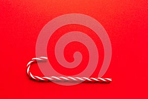 Christmas background.A candy cane on a red background,