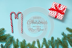 Christmas background with candy canes, gift , pine tree for design on blue background. Copy space. Flat lay. Top view.