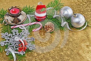 Christmas background, card with baubles, gift, fir and decorations over golden background