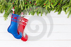 Christmas background. Christmas fir tree with decoration, red and blue Christmas socks on white wooden background, copy
