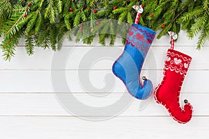Christmas background. Christmas fir tree with decoration, red and blue Christmas socks on white wooden background, copy
