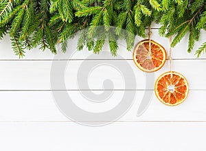 Christmas background. Christmas fir tree with orange decoration on white wooden board background, copy space