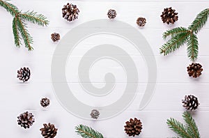 Christmas background. Christmas frame made fir tree branches, and pine cones decoration rustic elements on white trable.